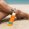 Frau cremt sich am Strand ein