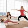 Mutter und Tochter praktizieren zu Hause Yoga mit Hund