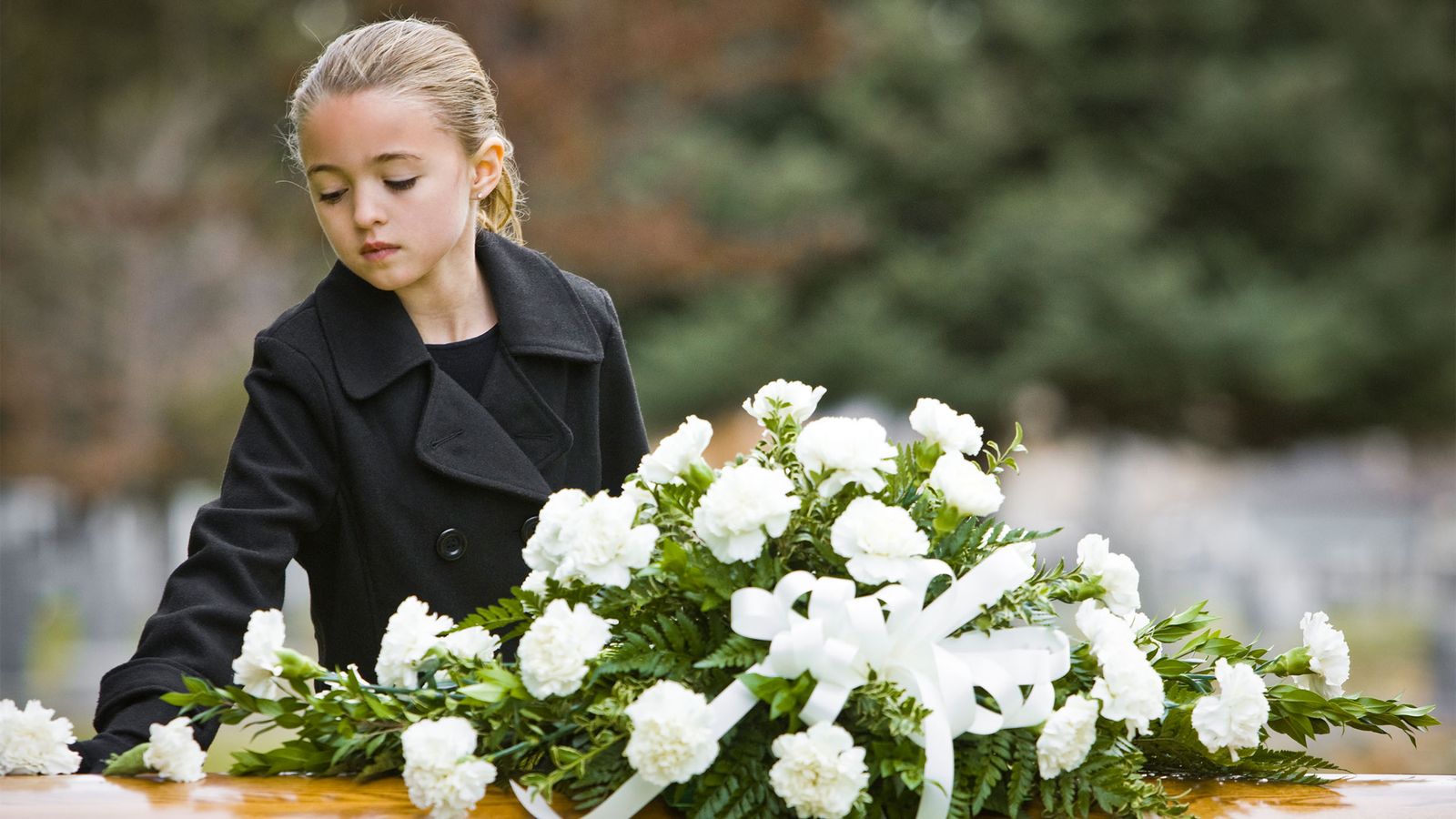 Junges Mädchen an einem Grab